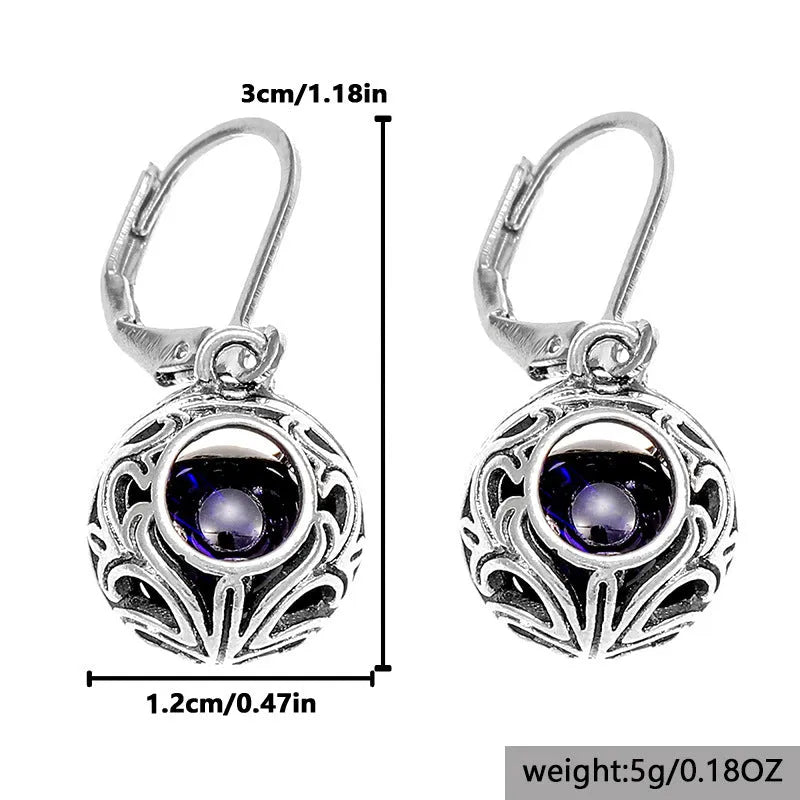 Silver geometric earrings with blue gemstone pendants and hollow engraving details