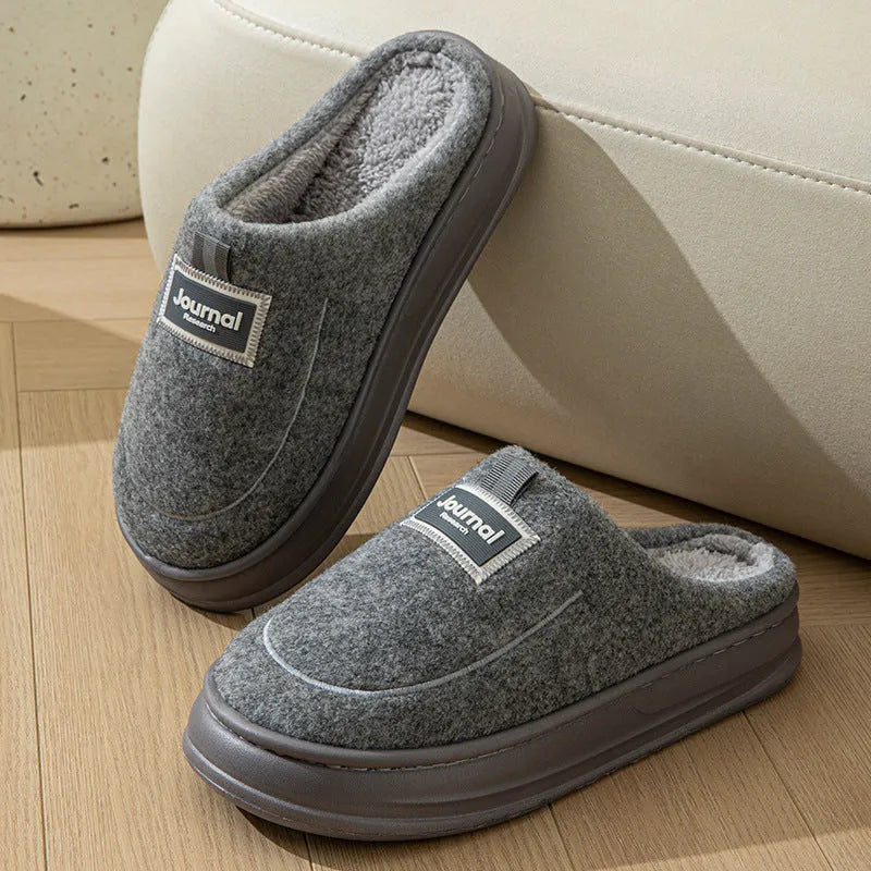 Men's brown suede slippers with a thickened sole on a wooden floor