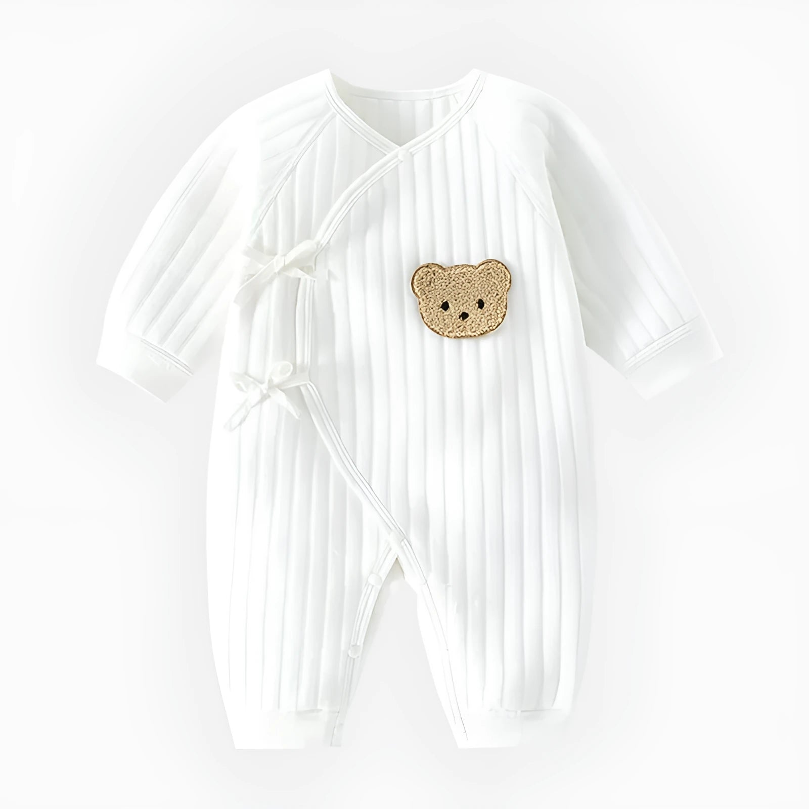 White cotton newborn jumpsuit with top fly lace closure and jacquard teddy bear straps