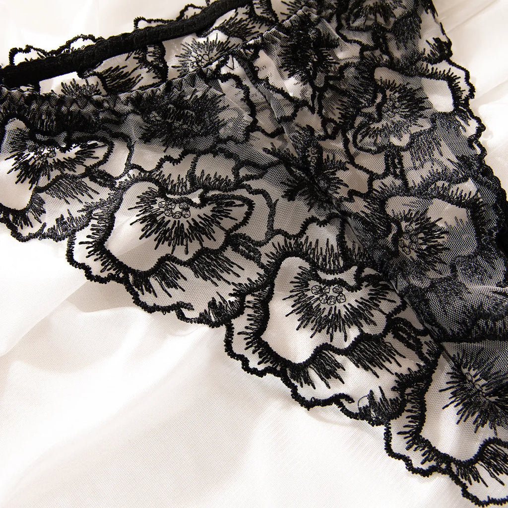 Black women's lace bikini underwear set with a decorative steel ring on sheer fabric.