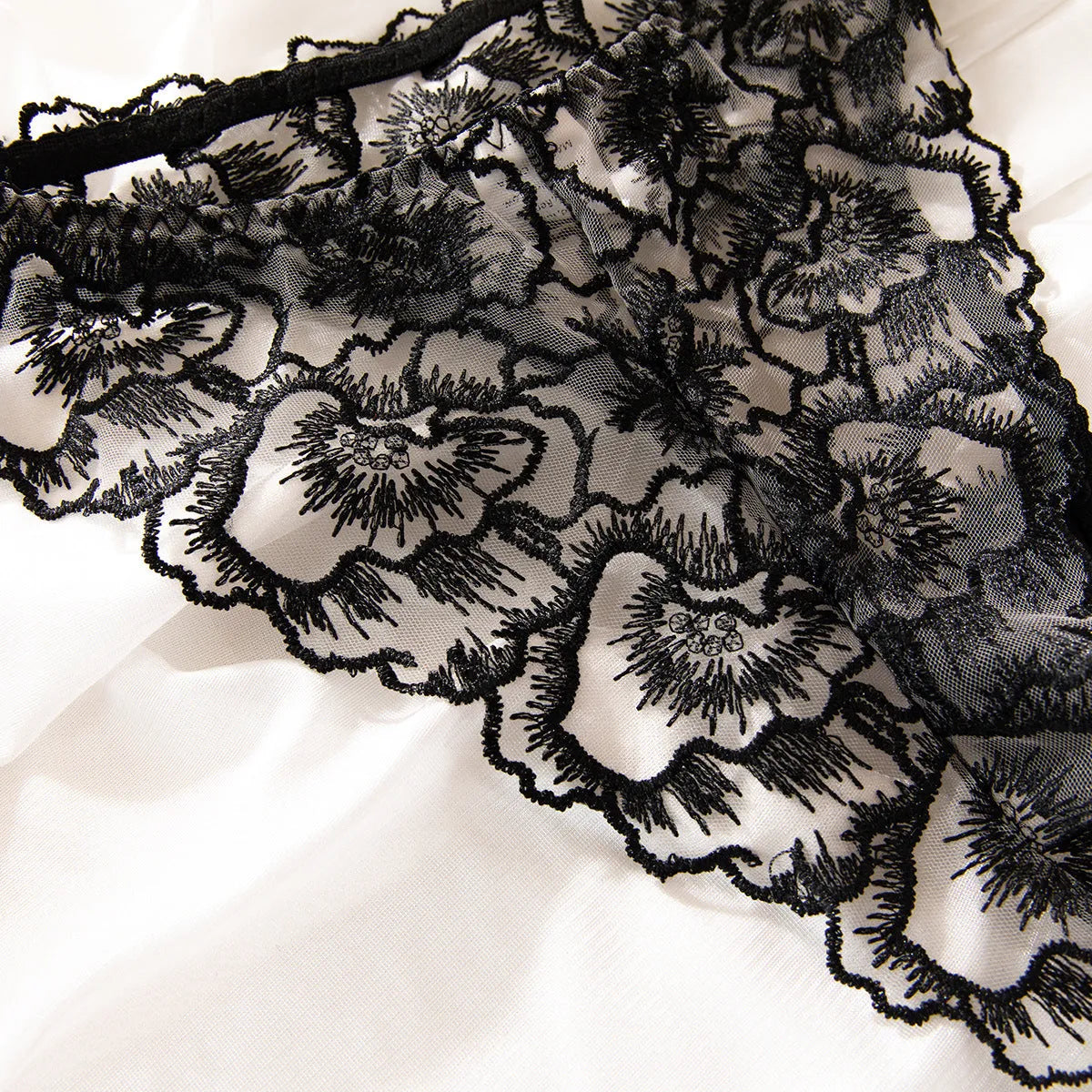 Black women's lace bikini underwear set with a decorative steel ring on sheer fabric.