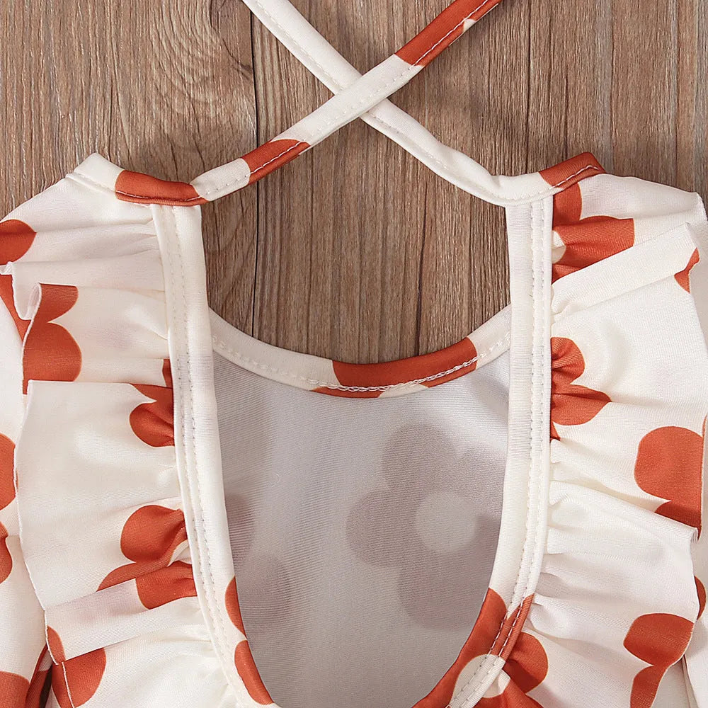 Girl's floral print open back swimsuit in orange red, shown from front and back.