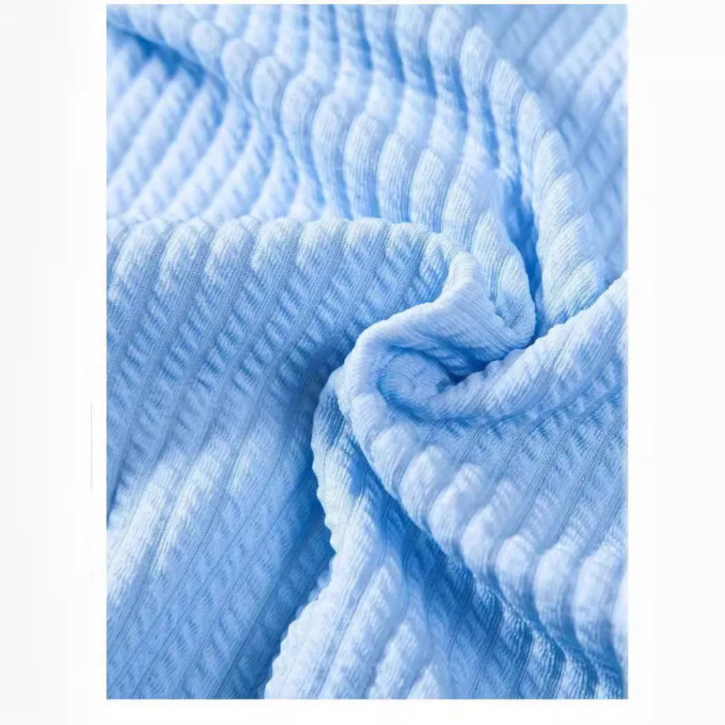 Man wearing a loose fit short sleeve polyester summer shirt in a light blue colour.