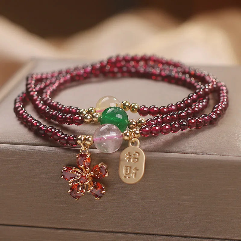 Women's natural crystal bracelet in pomegranate red cherry blossom colour with sequin details on strap.