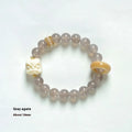 Hand-woven grey agate bracelet with 10mm round beads and mellite decorative accents.