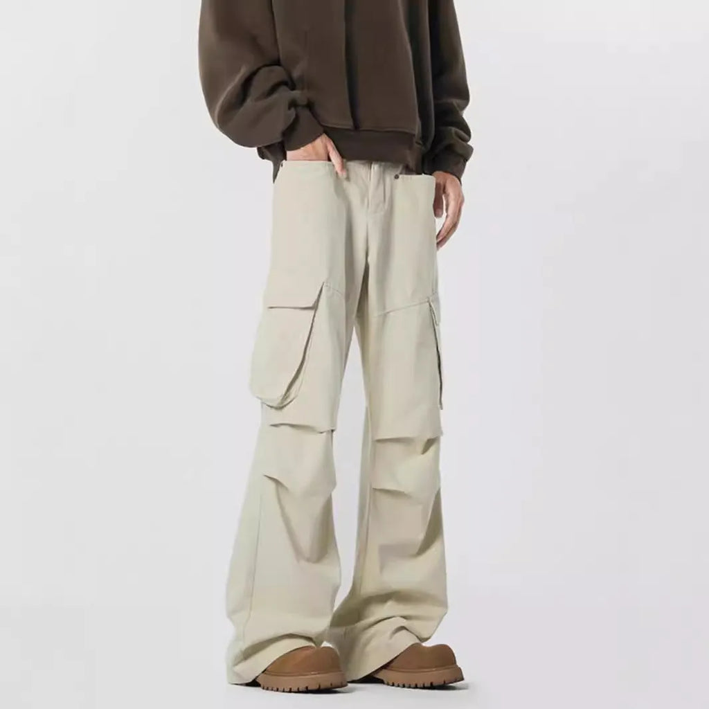 Men's black high-waisted straight-leg trousers with a button fly front, laid flat on a grey background.