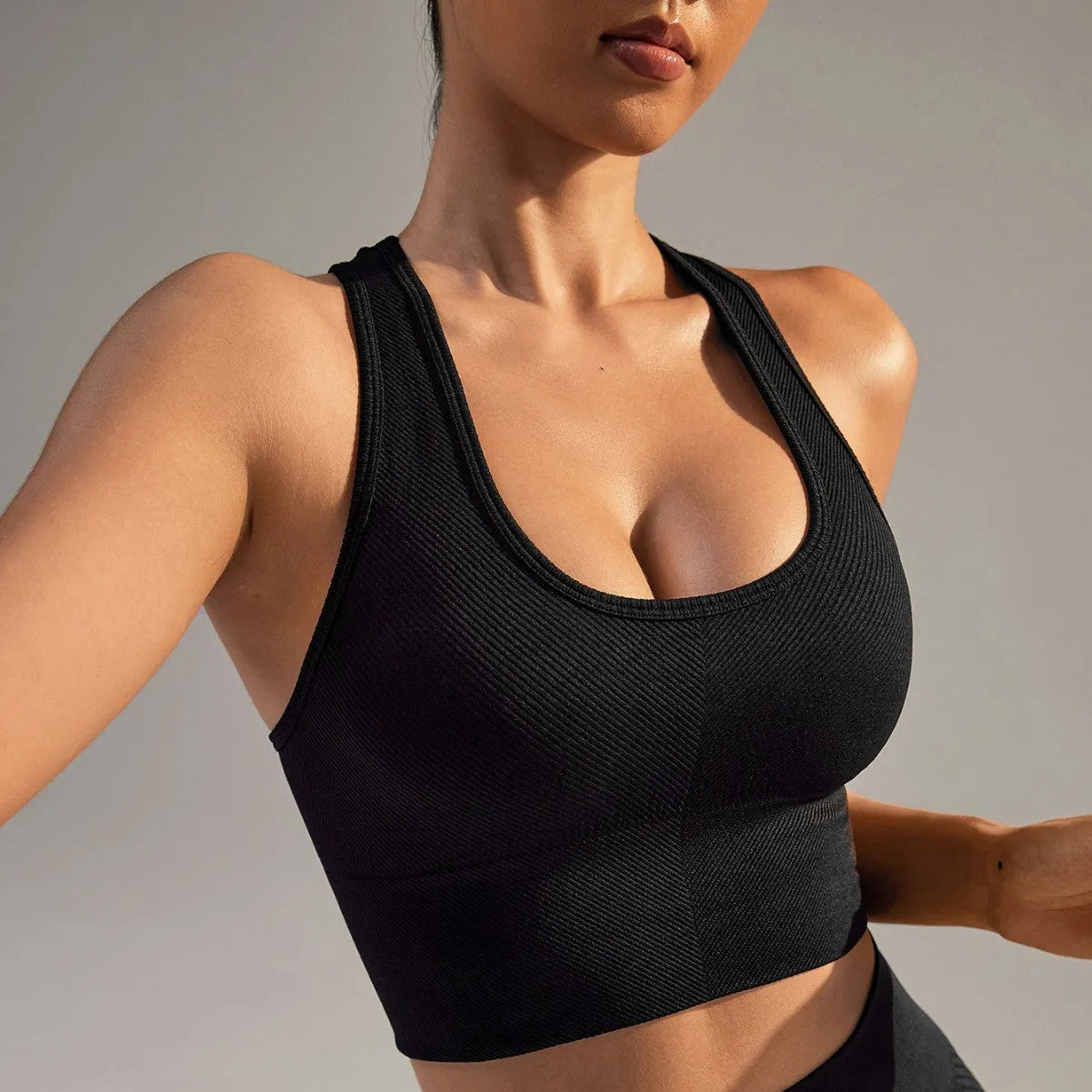 Black women's sports bra with cross-back design and moulded cups for running and yoga
