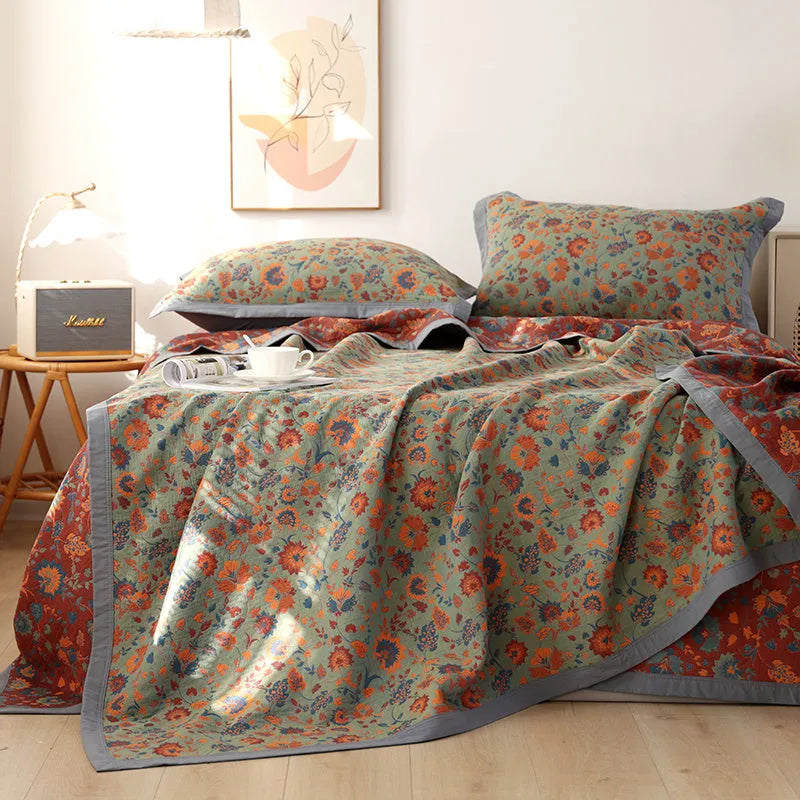 Cotton gauze floral blanket and two matching pillowcases laid out on a bed.