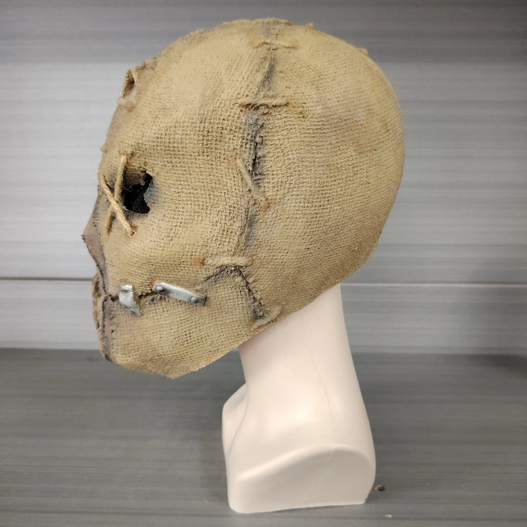 Latex Halloween horror mask with detailed scar skull design on a white background.