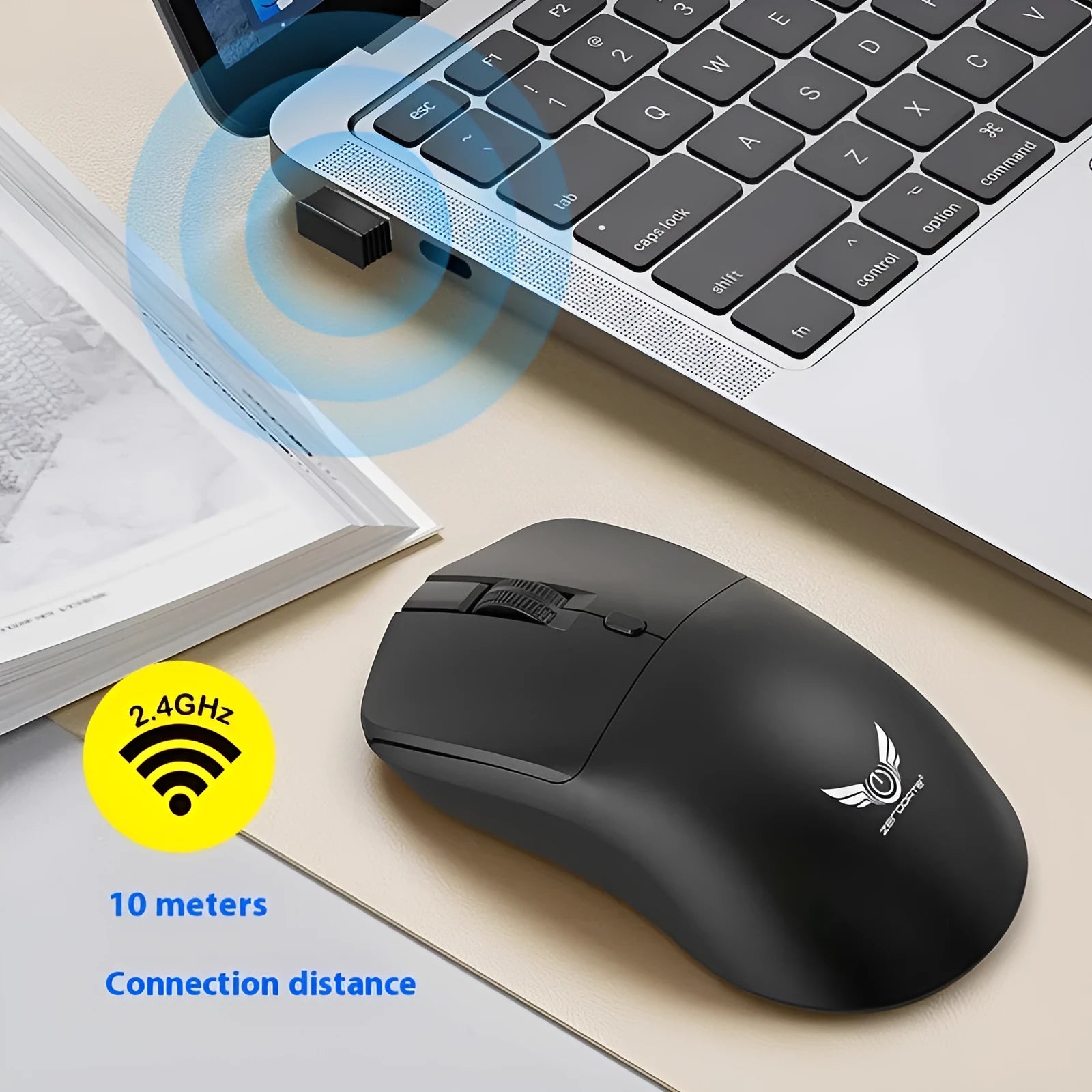 Black wireless mouse with a three-gear audio button on a desk next to a laptop.
