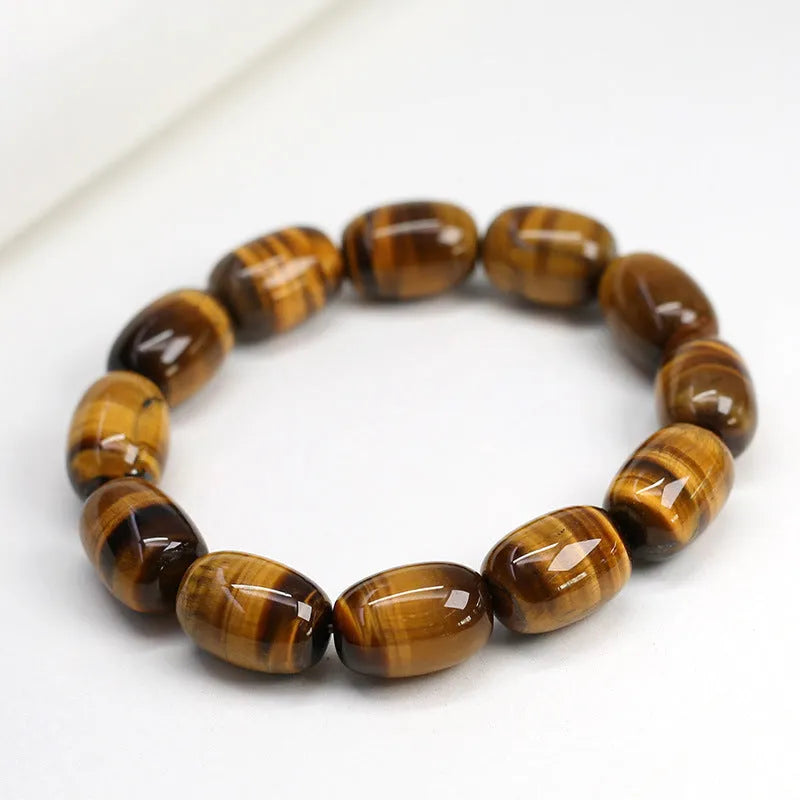 Yellow Tiger's Eye gemstone beaded bracelet with ethnic styling on a wrist.