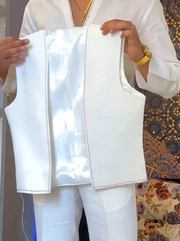 White three-piece outfit set showing V-neck shirt, sleeveless vest, and trousers laid flat