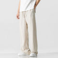 Man wearing beige straight-leg cropped linen-style trousers with a drawstring waist.