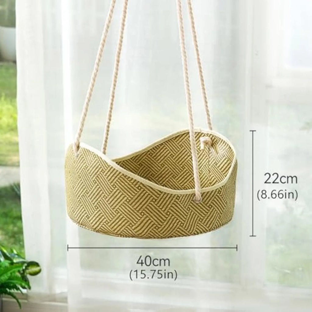 Green woven rattan cat hammock with metal hooks, hanging on a white shelf with a cat resting.