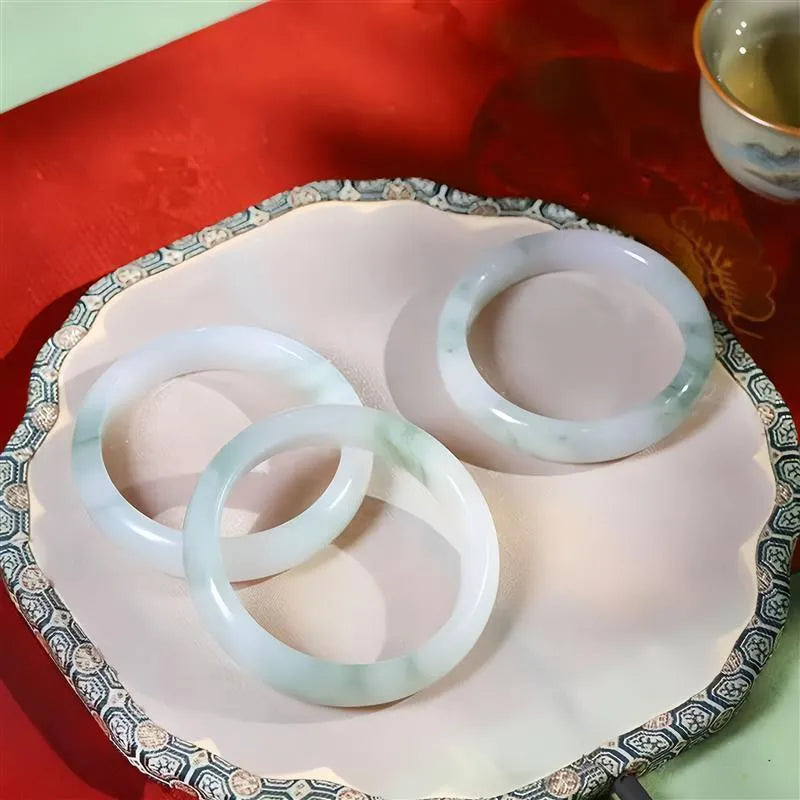 Tian Shan Cui bracelet with floating flower design and animal charm, showing icy clear mineral.