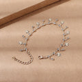 Gold alloy butterfly tassel anklet with colourful floral and leaf design on foot for summer beach wear