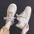 Women's pink low-top sneaker with imitation leather upper and rubber sole on a plain background.