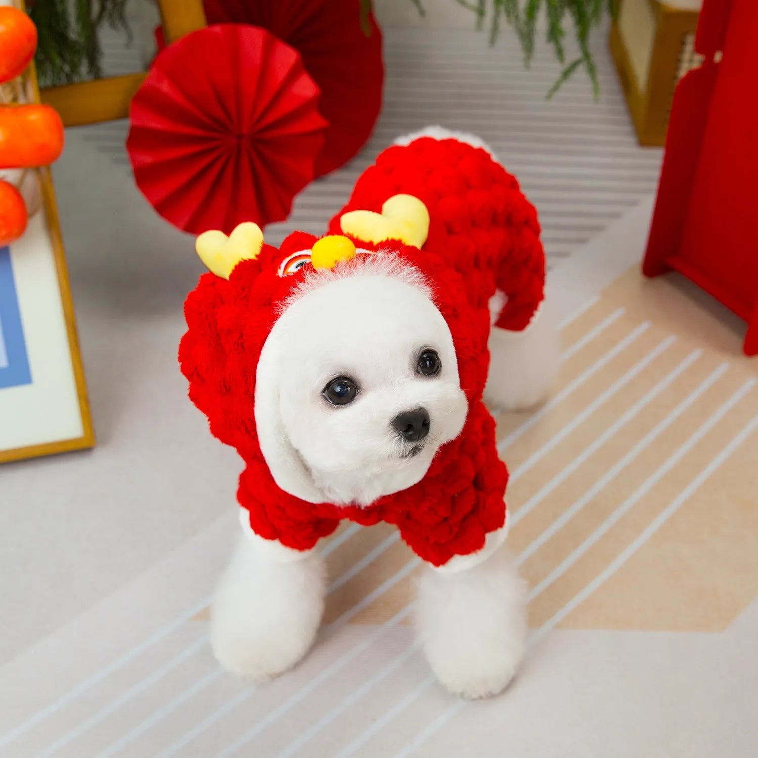 Red velvet pet jacket with cartoon dragon design for dogs and cats on a hanger