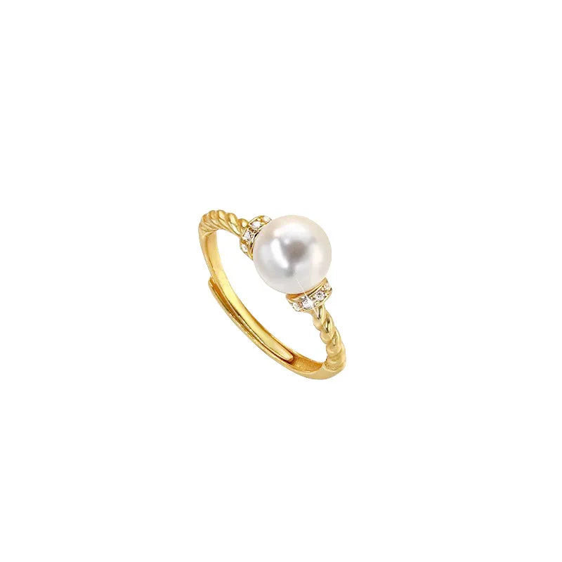 Geometric antique twist ring with a central pearl, on an adjustable copper band in gold colour.