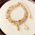 Gold electroplated bracelet with three circles of caramel citrine and a Saturn charm.