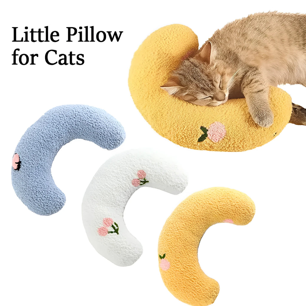 Small white half-donut U-shaped plush pillow for a cat or small dog on a carpet