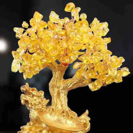 Citrine-coloured resin Feng Shui ornament of a small turtle on a money tree.