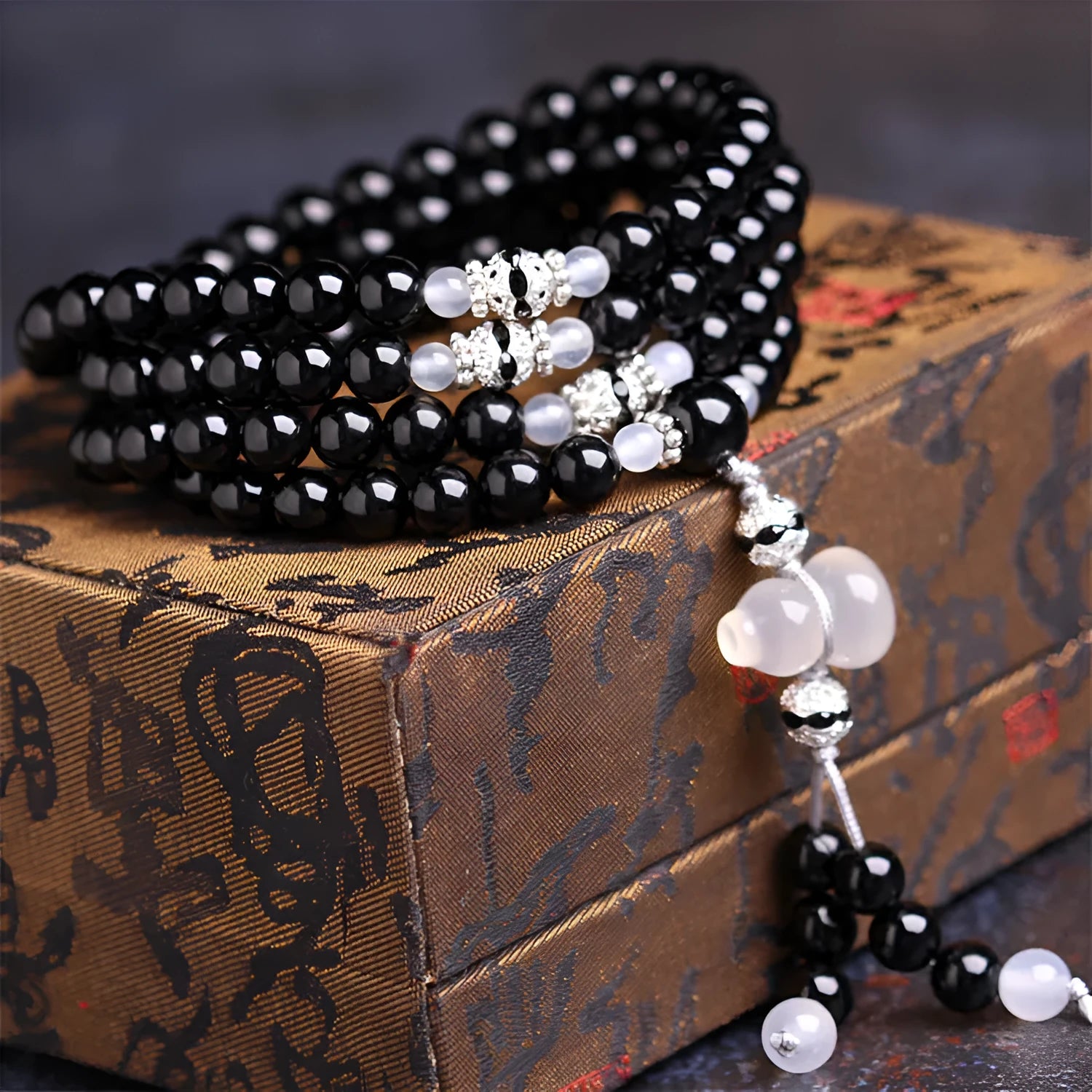 Black agate bracelet with 108 geometric beads on a wrist.