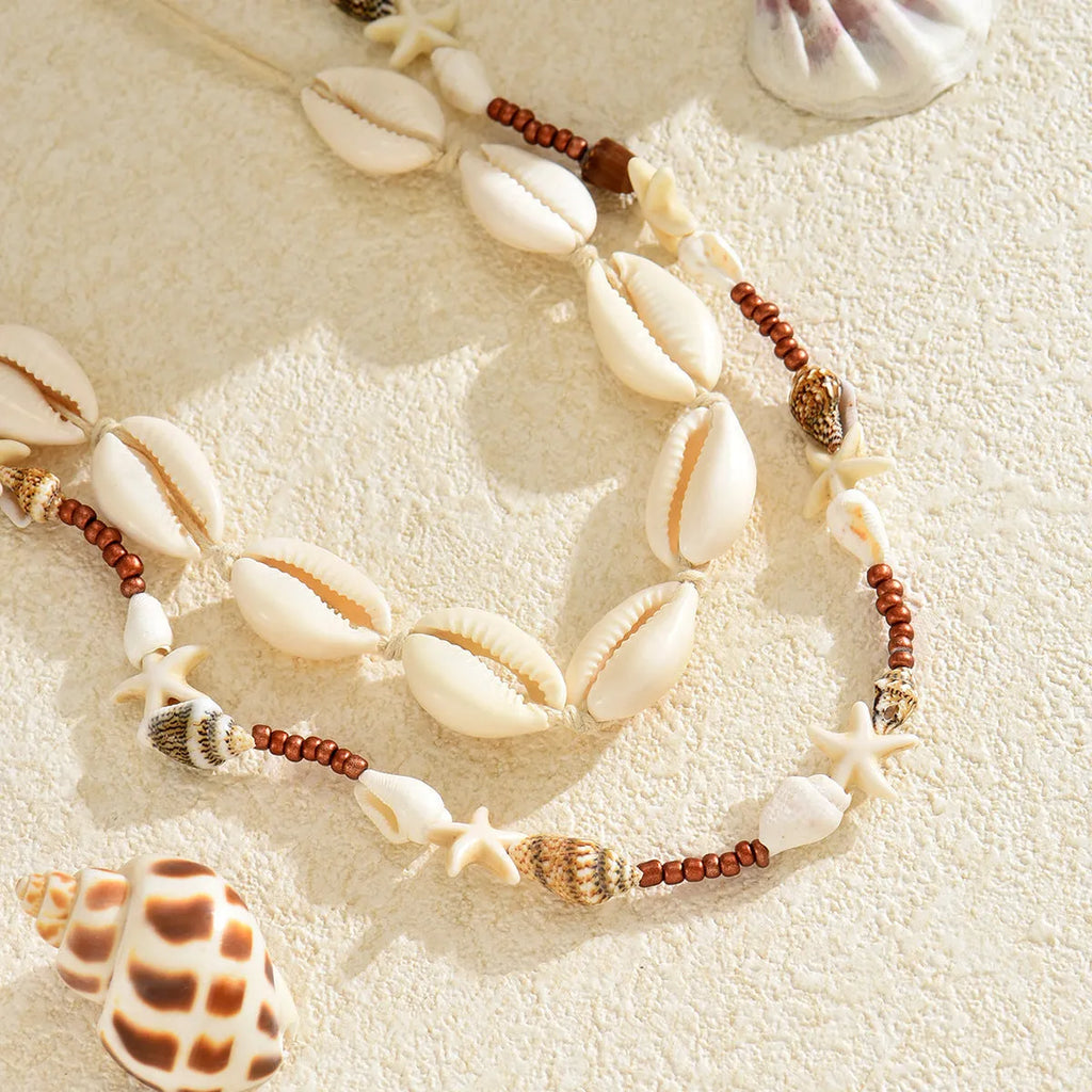Handcrafted bohemian shell necklace with geometric pendant on a regular chain, colour X1900.