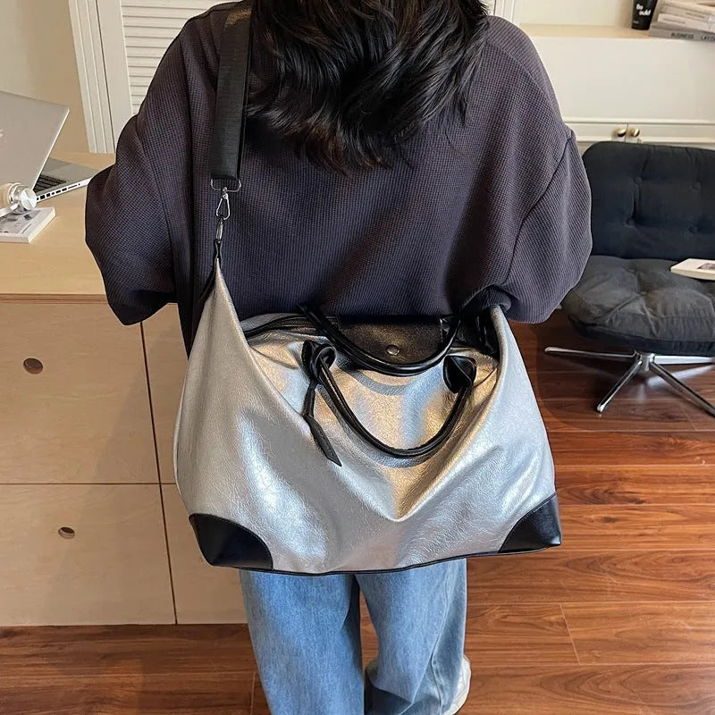 Women's hand-carrying travel bag in black or silver with 36-55L capacity
