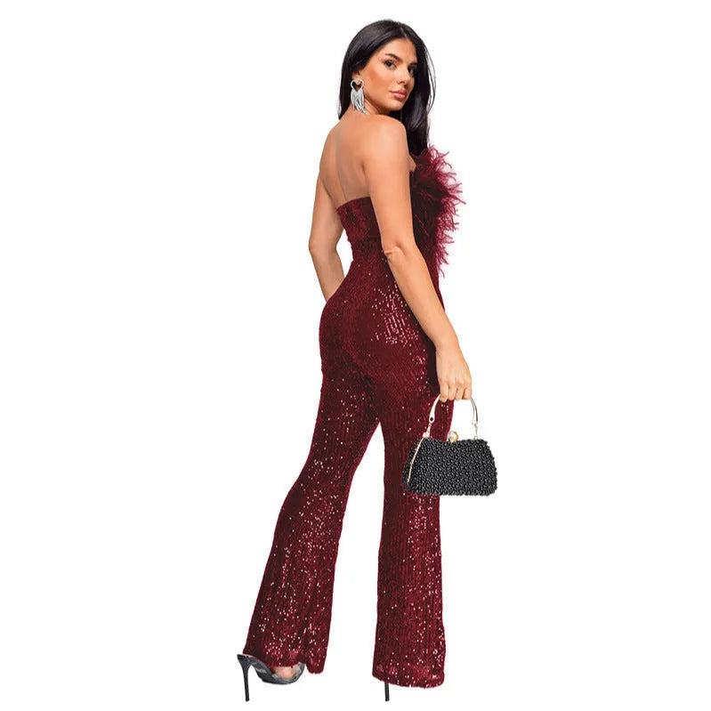 A woman models a black sleeveless, backless jumpsuit with flared legs and sequin details.