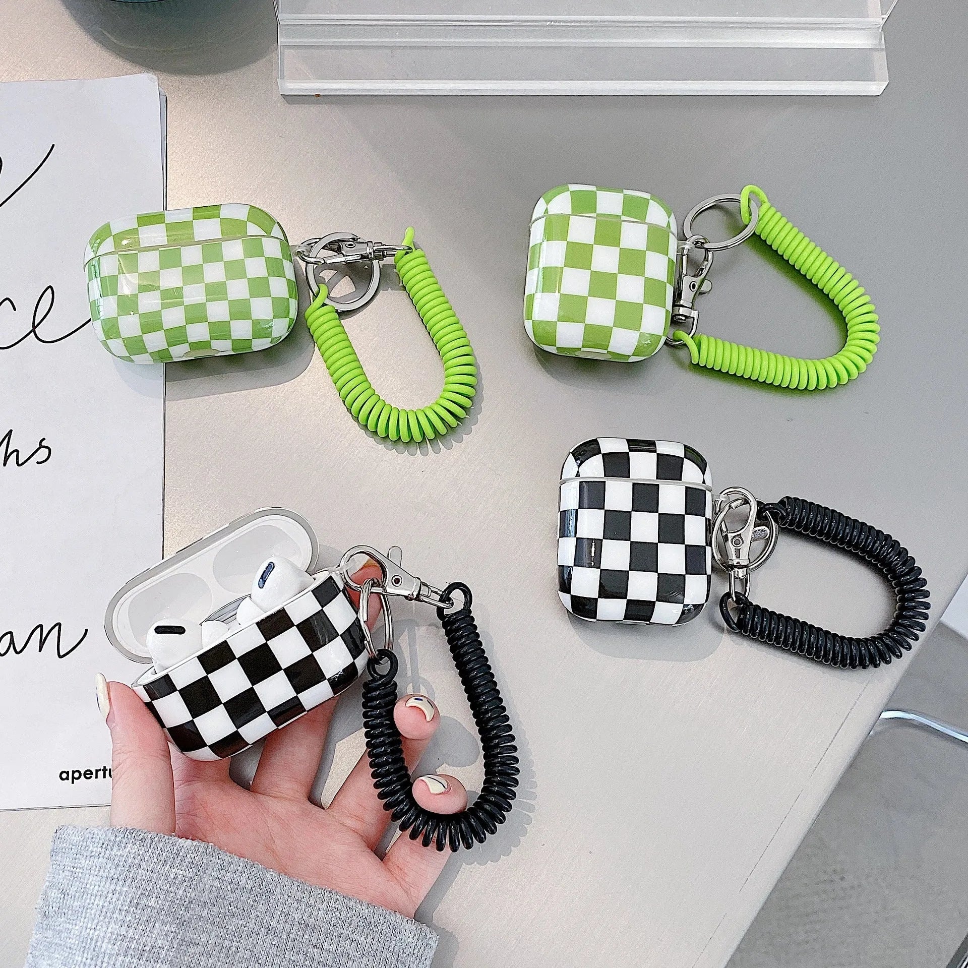 Black and green checkerboard pattern TPU case for Apple AirPods with optional lanyard and pendant accessories.