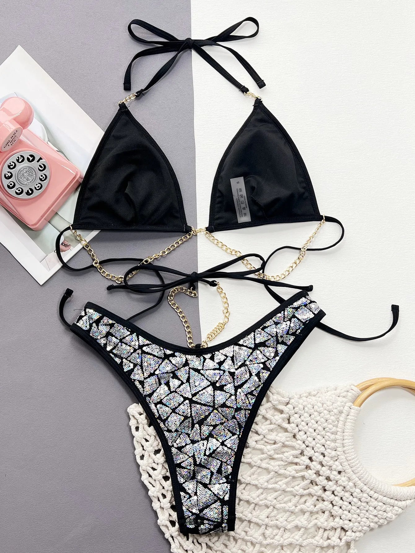 Silver black women's bikini with metallic chain detail, showing top and briefs.