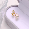 A pair of geometric sterling silver earrings with sweet white crystal studs on a white background.