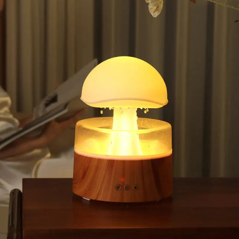 White cloud-shaped humidifier and aroma diffuser with LED lights and simulated raindrops.