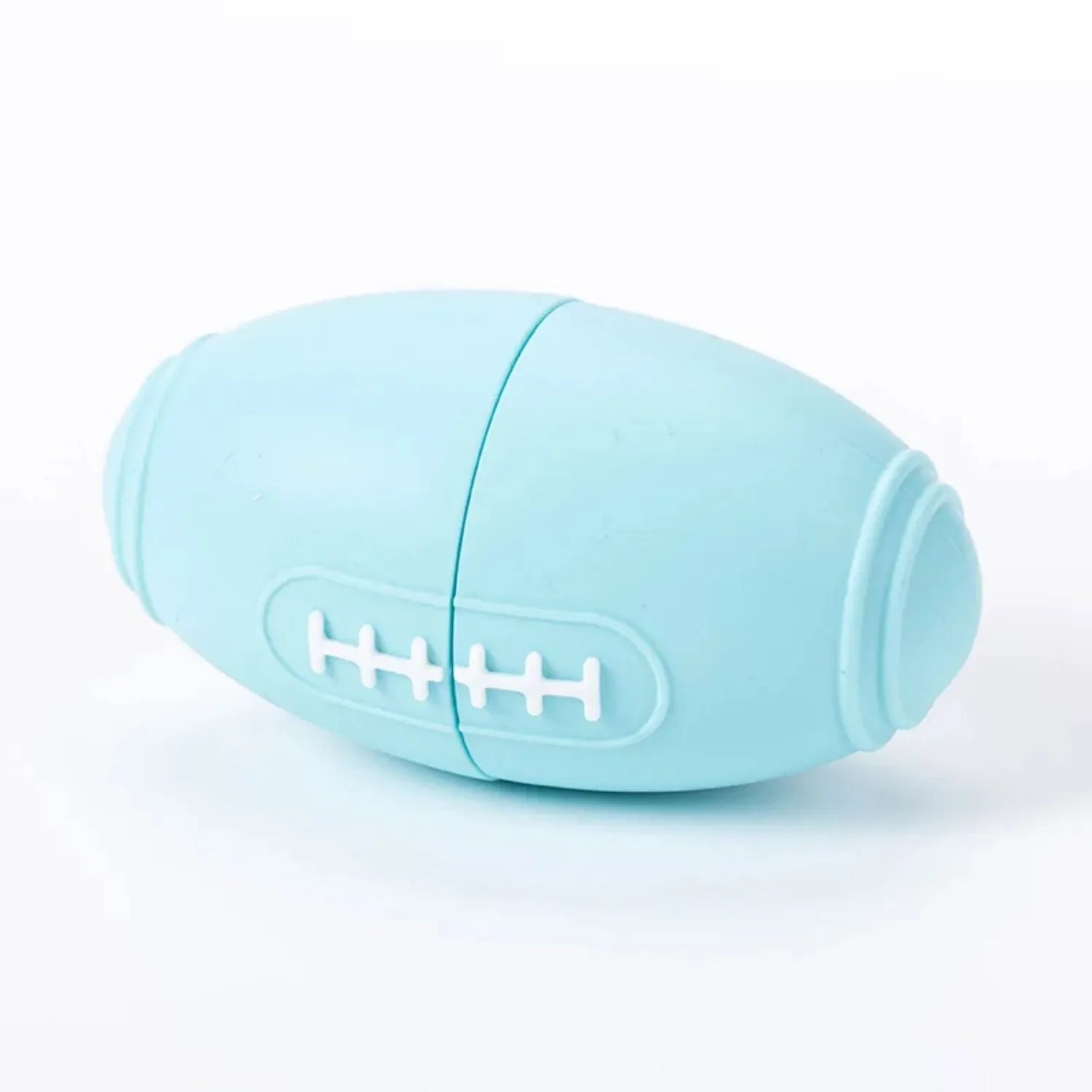 Blue silicone rugby ball dog chew toy with multiple small food leak holes on a white background.