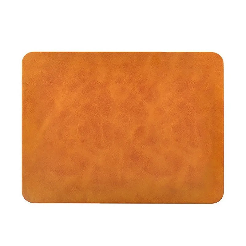 Brown leather wireless charging mouse pad with Micro USB port on a wooden desk.