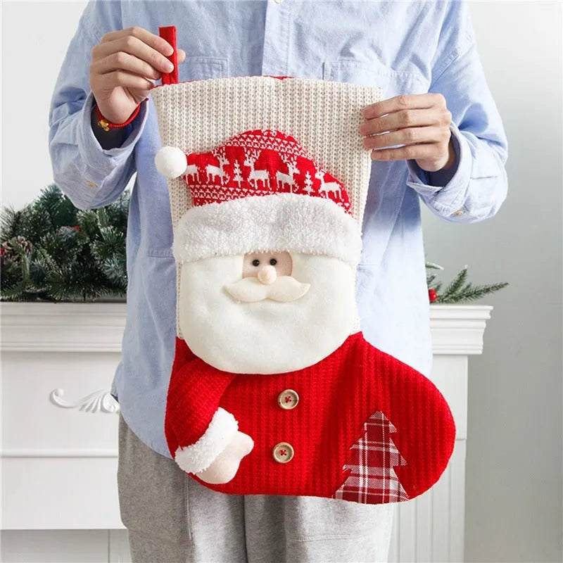 Large red and white knitted Christmas stocking with Santa Claus design hanging on a fireplace.