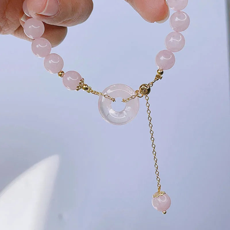 Pink crystal bracelet with peace symbol safety buckle clasp on woman's wrist