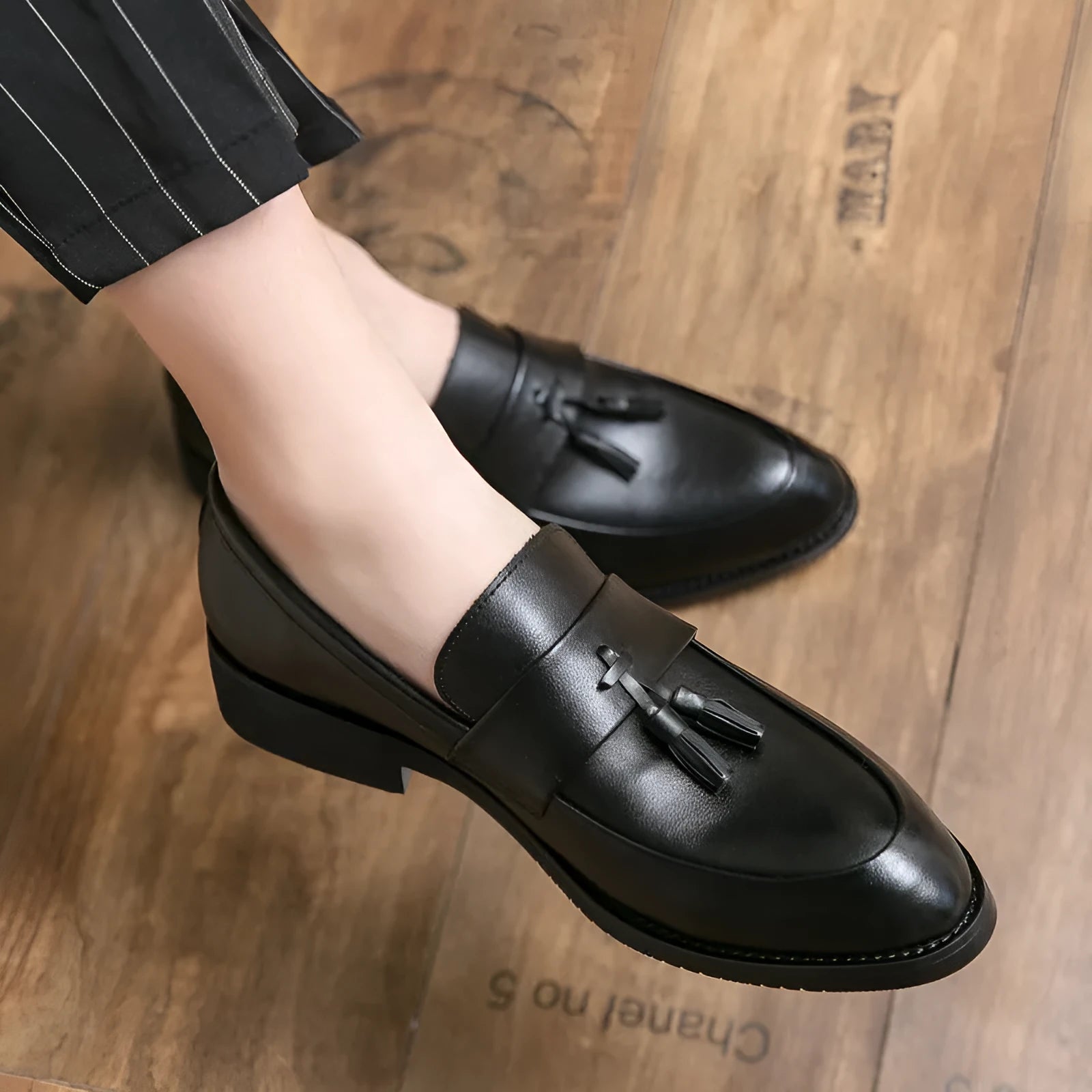 Men's black slip-on business casual shoes with tassel detailing and rubber sole