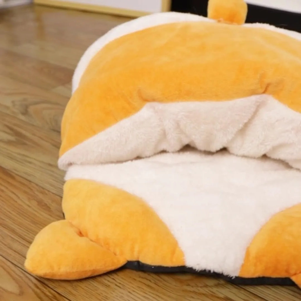 Orange semi-enclosed cat sleeping bag bed on a floor, showing its nest shape and dimensions.