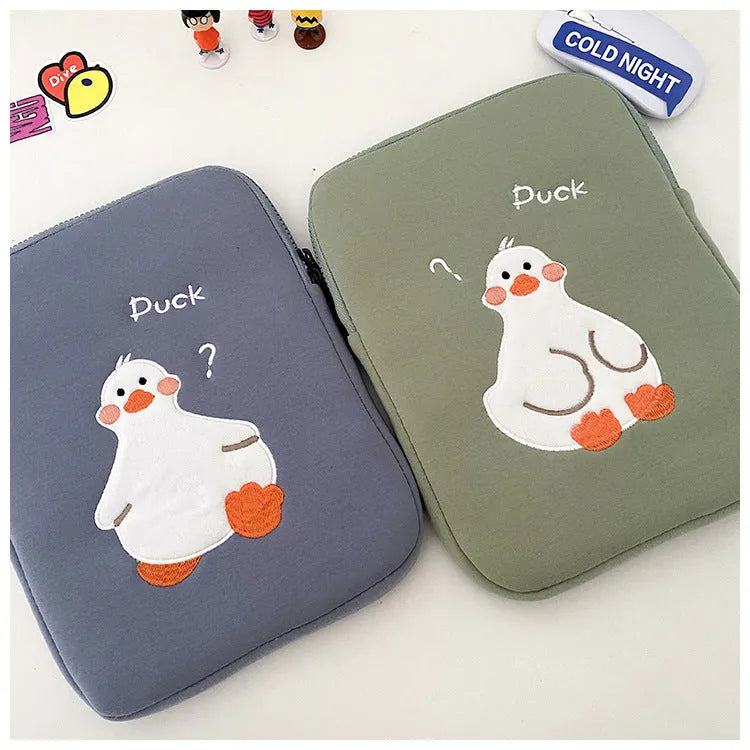 Blue cotton tablet case with cartoon duck embroidery and a zipper, shown next to a green version.