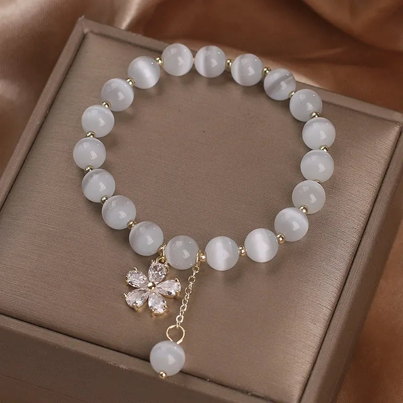 Women's white cat's eye stone bracelet with morganite pendant and flower tassel on safety buckle clasp