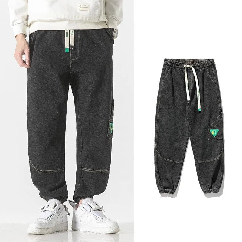 Men's loose-fit tapered cotton trousers in mid-waist design, shown in black colour.
