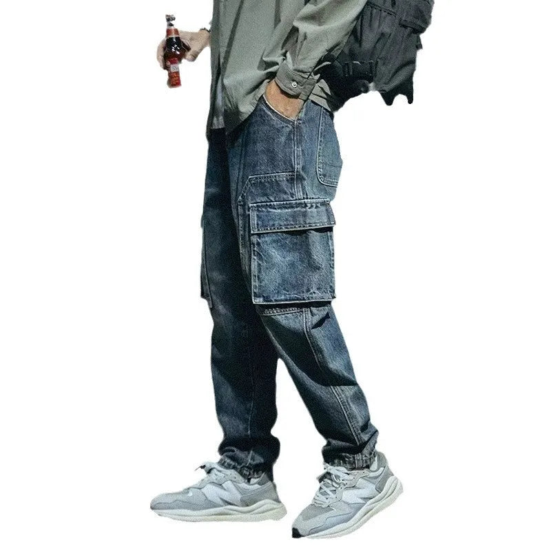 Man wearing blue loose straight-leg stretch denim trousers for a casual retro look.