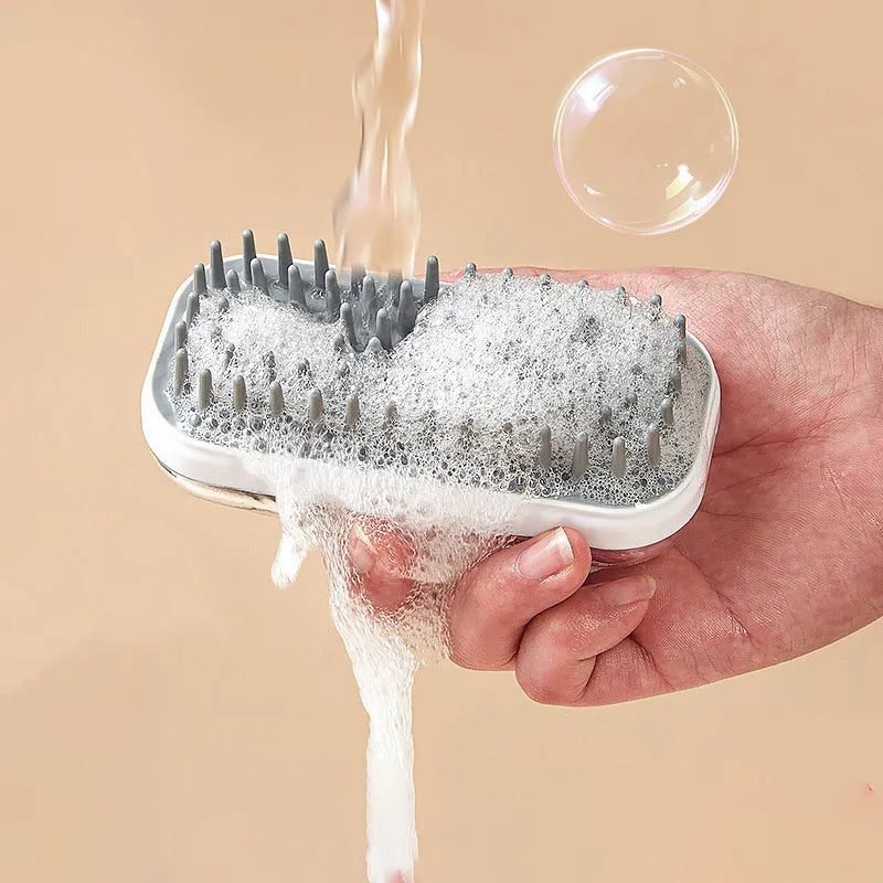 Grey silicone pet bath brush with a long handle next to a pink one, showing soft bristles for washing dogs and cats.