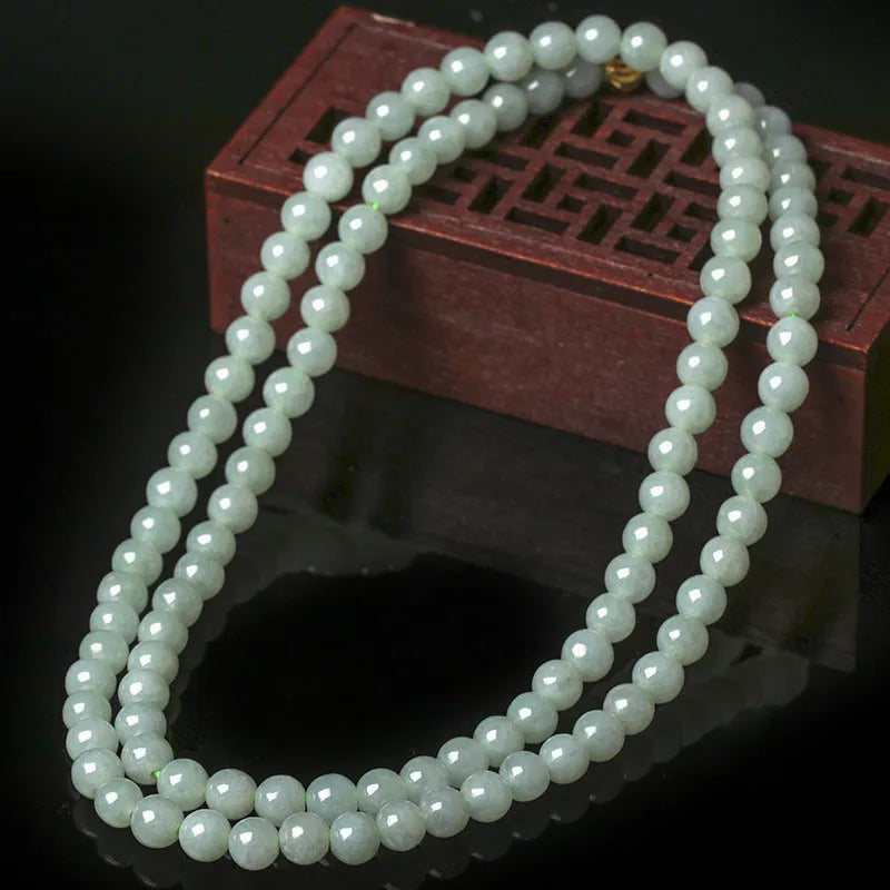 Natural white-green jade bead necklace with adjustable chain and 6.5mm round beads on grey background