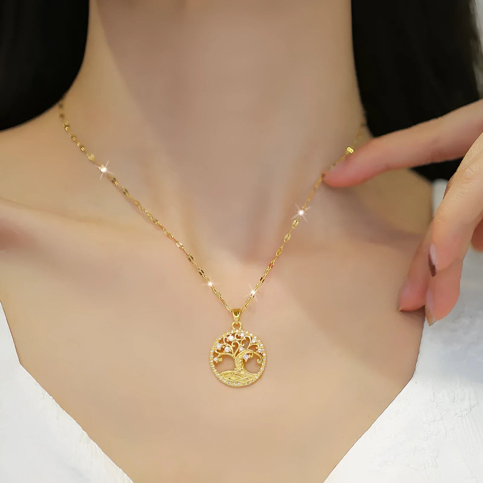 Gold-plated stainless steel necklace with mother-of-pearl and rhinestone pendant on a lip chain.