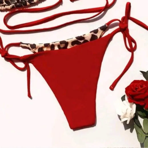 Red leopard print women's bikini with halter neck and lace-up front detail.