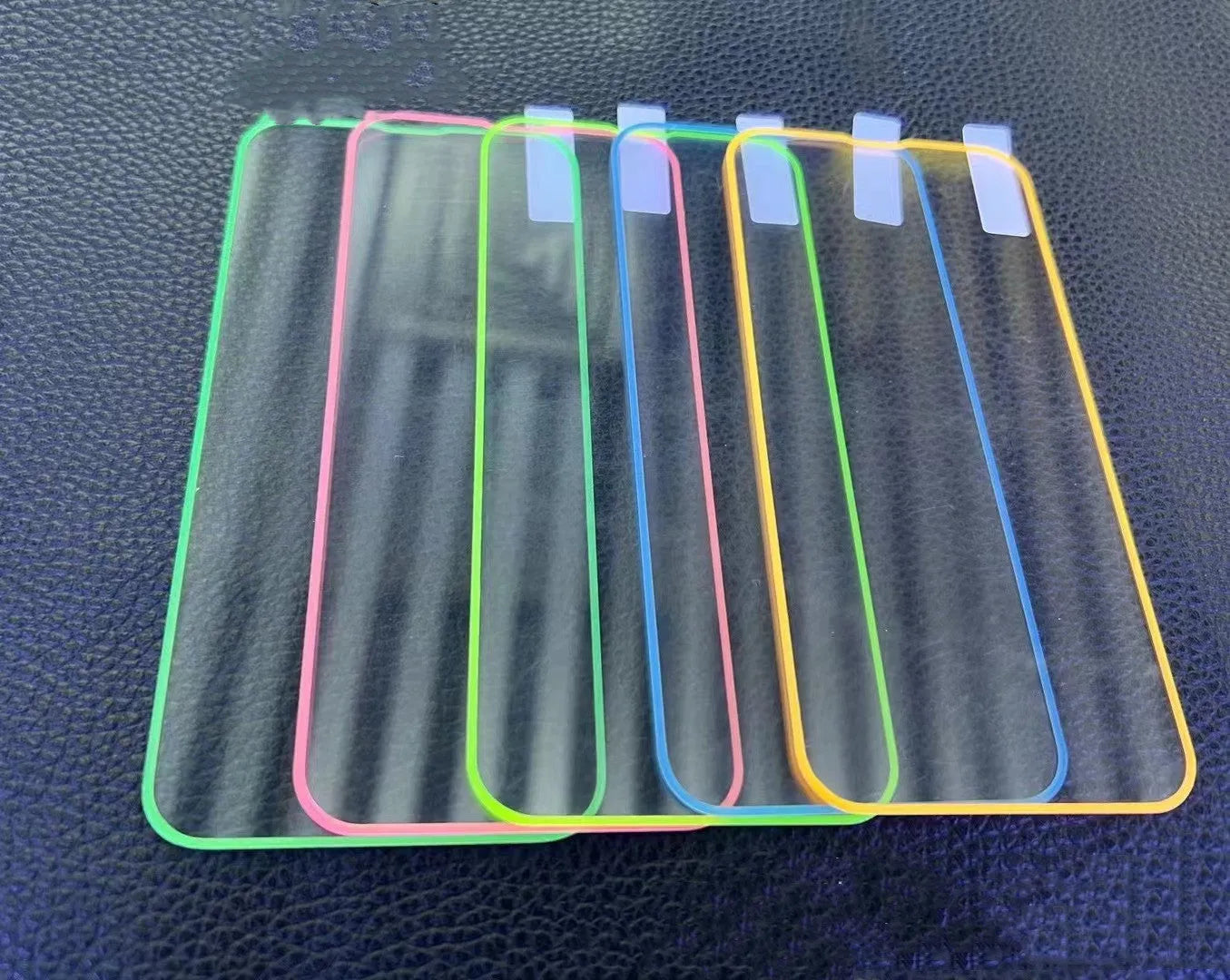 Luminous pink tempered glass screen protector fitted on an iPhone, showing full screen coverage and glow.