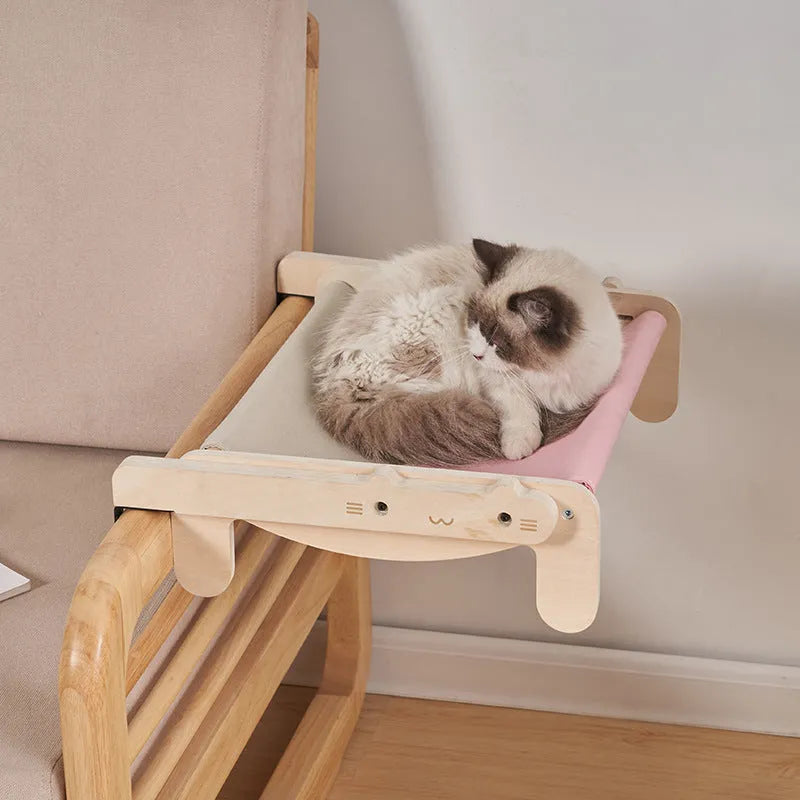 Solid wood cat bed with a removable patterned cover on a wooden floor